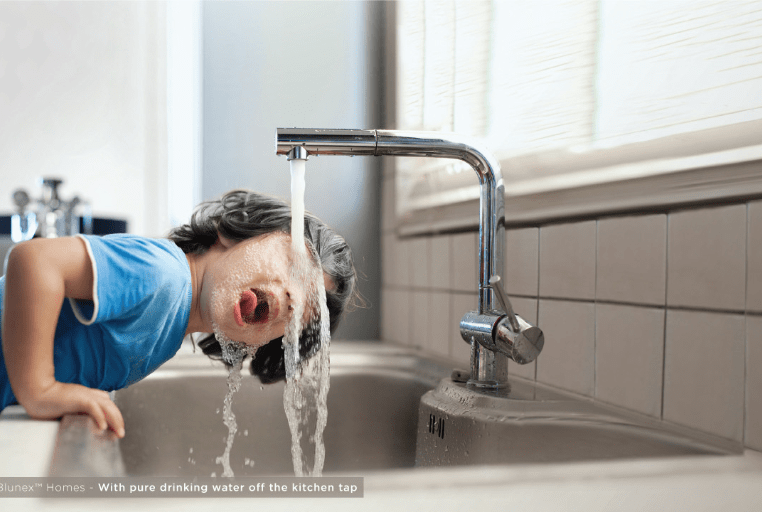 boy drinking water from tap